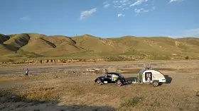 teardrop caravan being towed across a field 